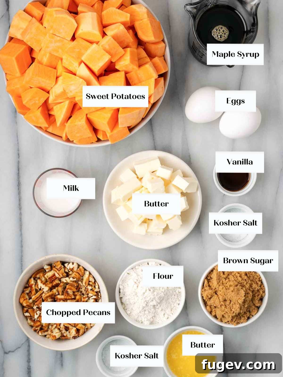 Golden Pecan Sweet Potato Bake 5 All the essential ingredients for sweet potato casserole laid out on a marble surface, including sweet potatoes, maple syrup, eggs, butter, pecans, and brown sugar.