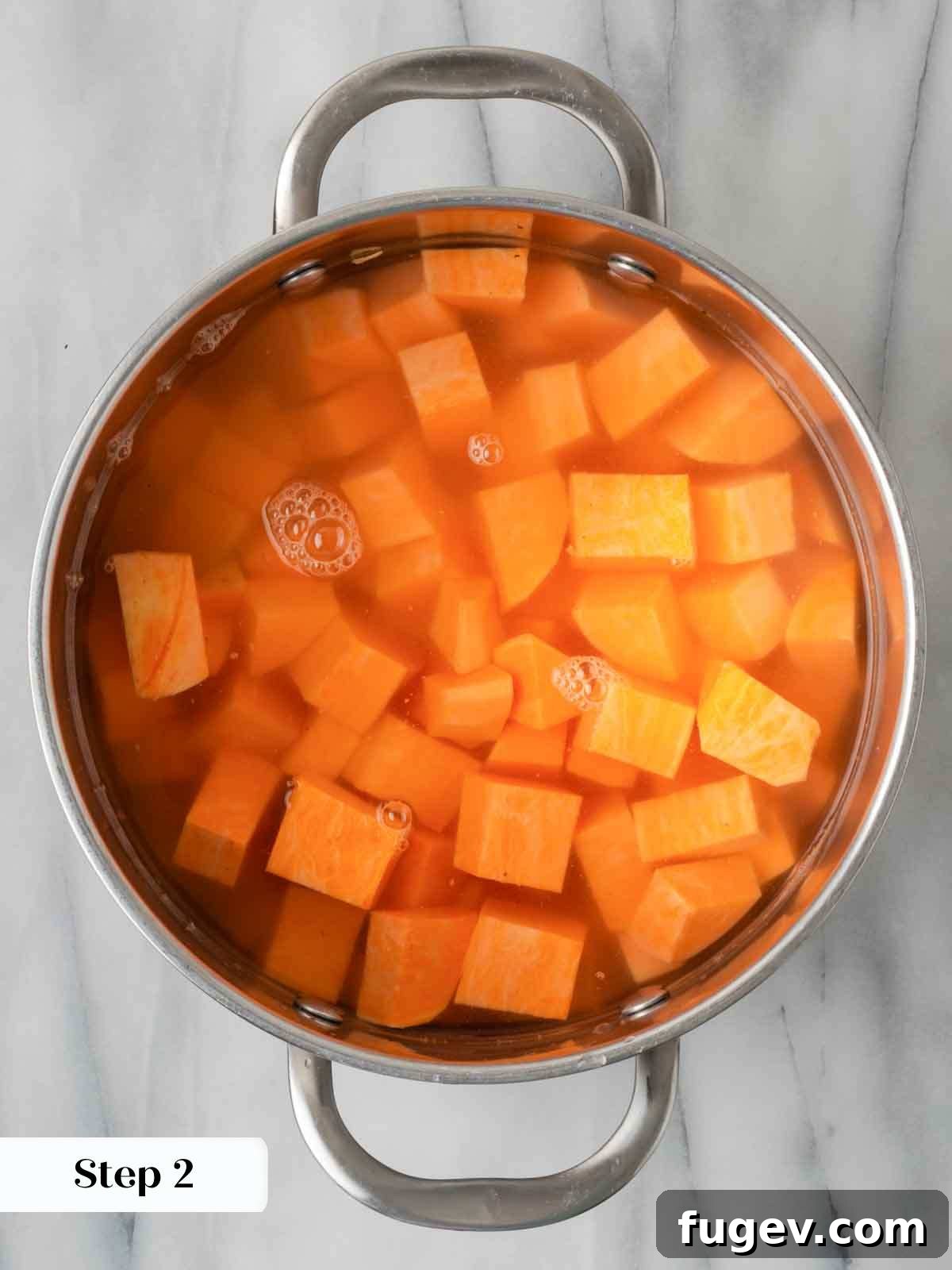 Golden Pecan Sweet Potato Bake 6 Sweet potatoes boiling in water in a pot on the stove.