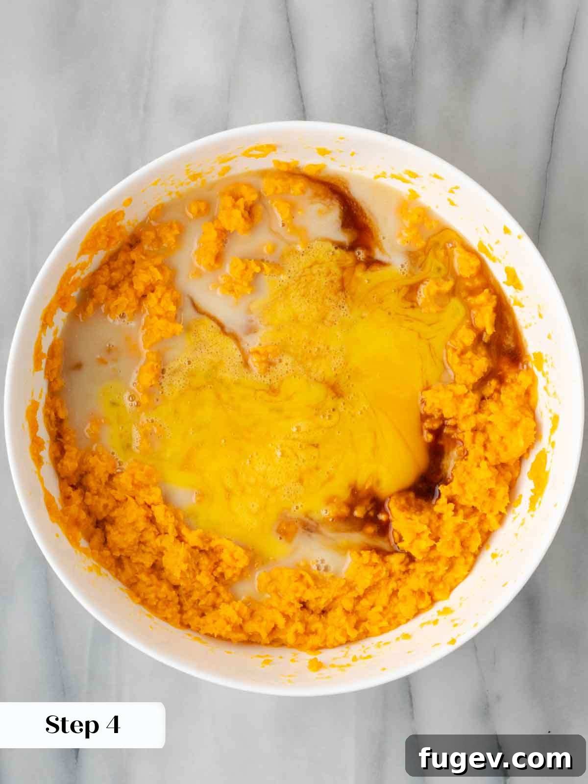 Golden Pecan Sweet Potato Bake 8 Mixing the sweet potato casserole base ingredients in a bowl with a spoon.
