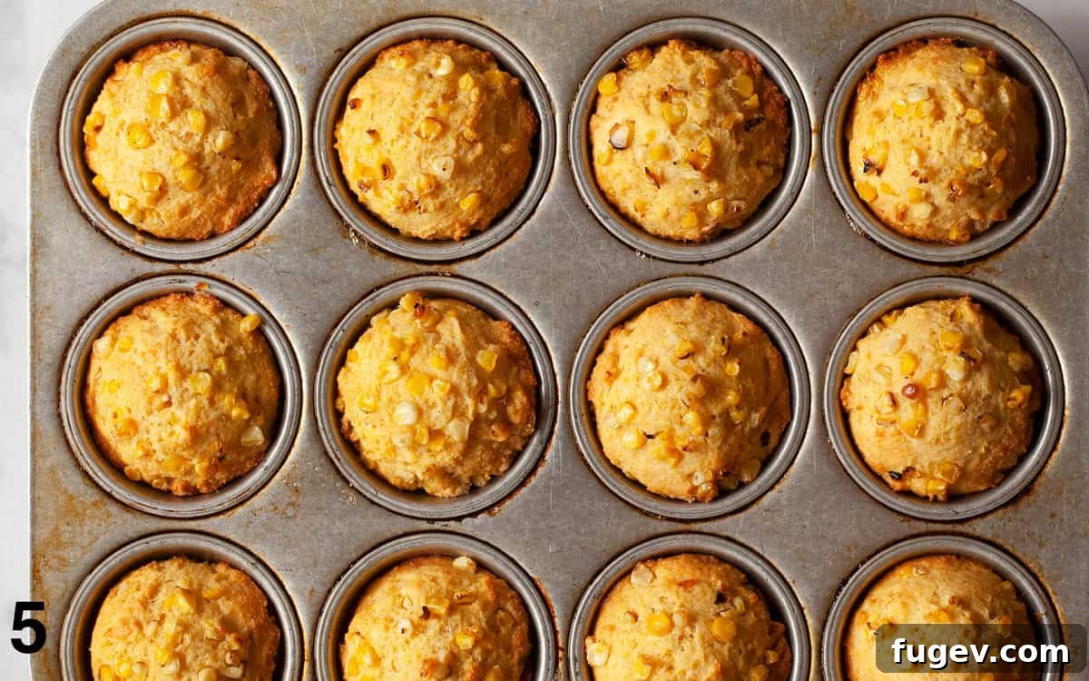 Smoky Sweet Cornbread Muffins 8 Freshly baked golden cornbread muffins cooling in a muffin pan, ready to be enjoyed.