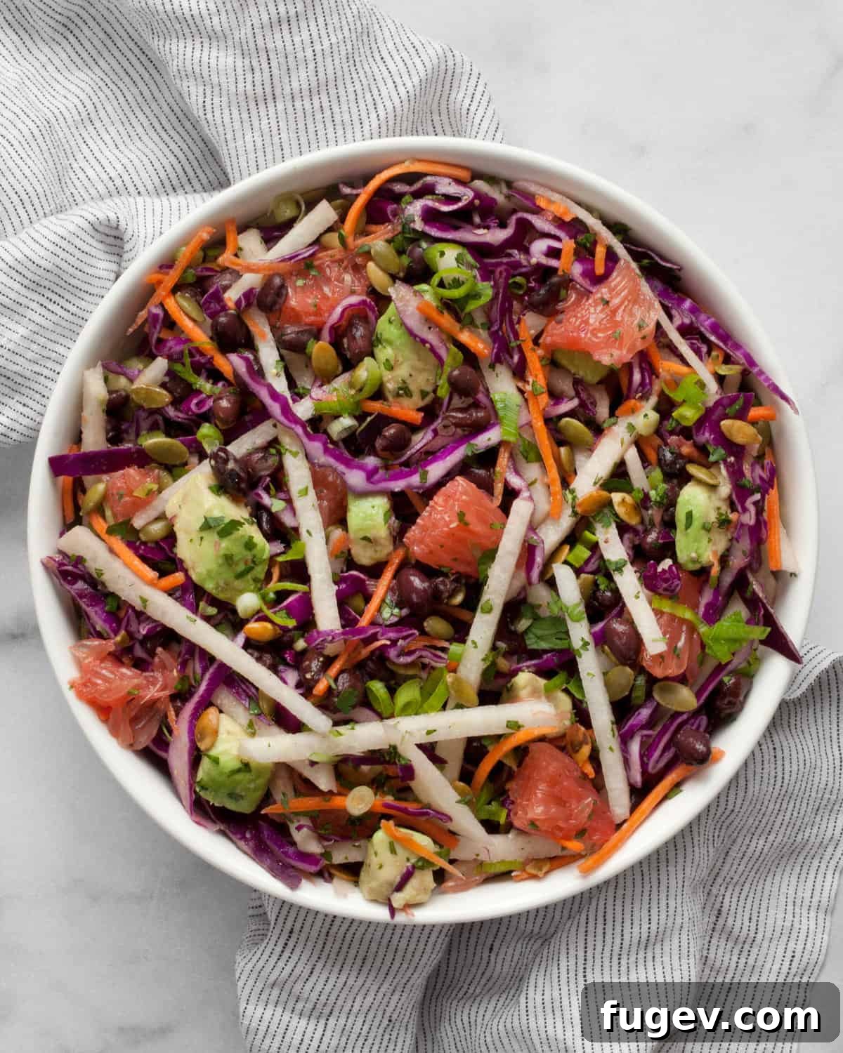 Zesty Jicama Crunch Salad with Black Beans and Cabbage 2 A beautifully arranged jicama salad with grapefruit and cabbage in a large ceramic bowl, showcasing its vibrant colors and crisp texture.
