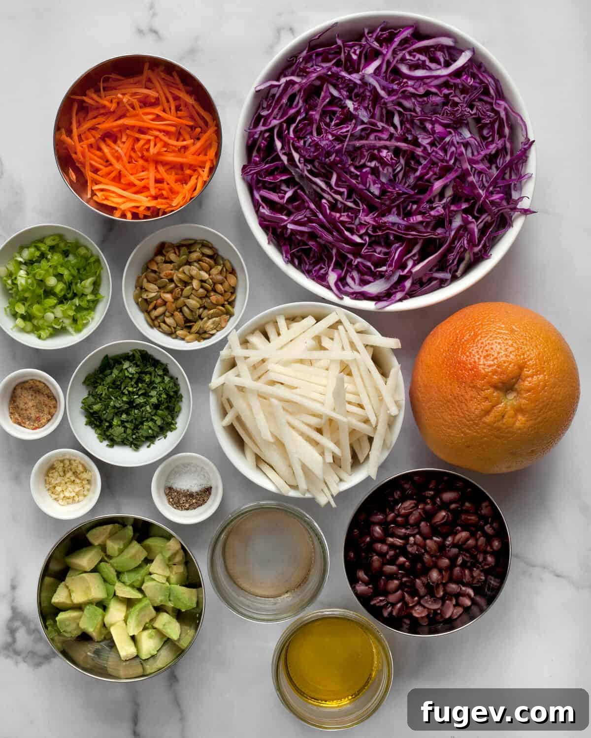 Zesty Jicama Crunch Salad with Black Beans and Cabbage 3 All the fresh ingredients for the jicama salad laid out on a wooden surface: jicama, red cabbage, carrots, grapefruit, black beans, avocado, cilantro, and pepitas.