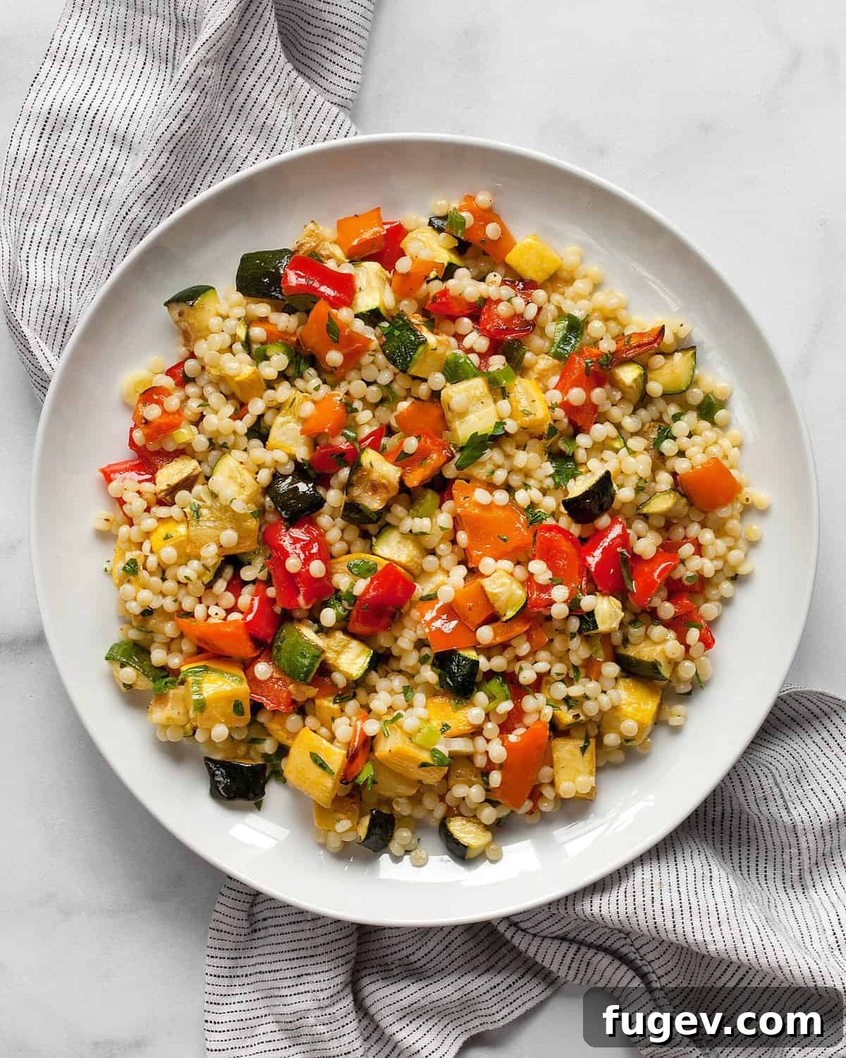 Bright Lemon Tahini Roasted Vegetable Couscous 2 A beautifully plated dish of roasted vegetable couscous with lemon and tahini, garnished with fresh herbs.