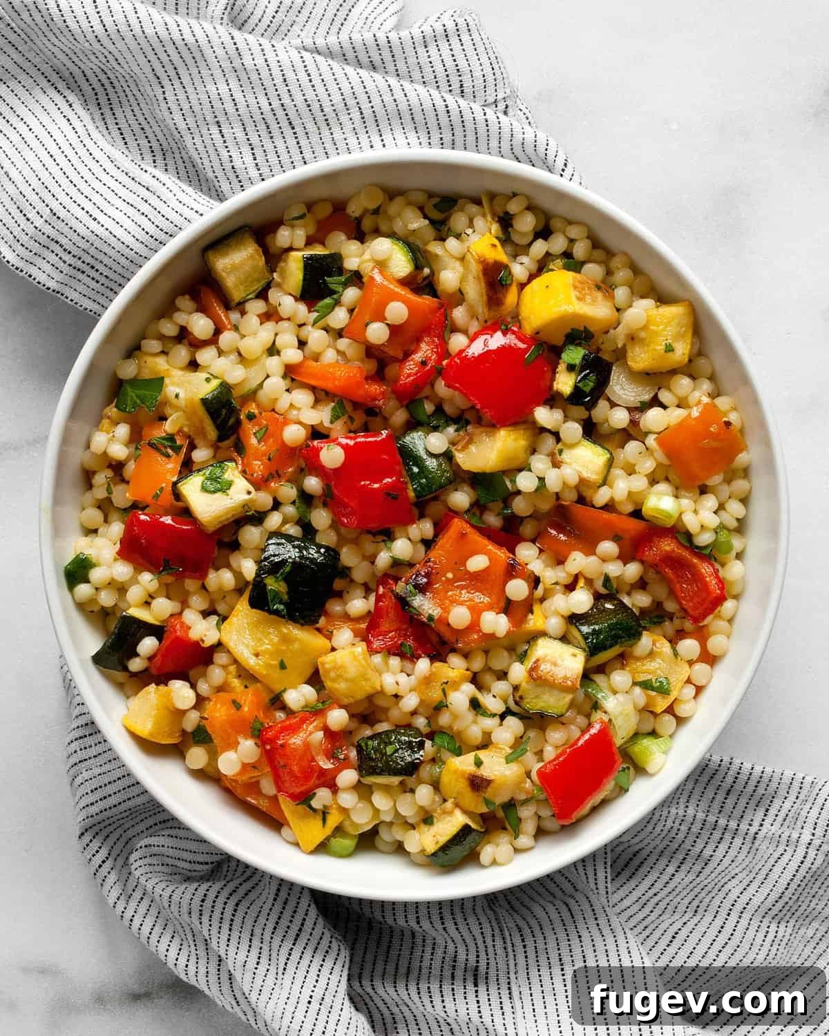Bright Lemon Tahini Roasted Vegetable Couscous 7 Close-up shot of roasted vegetable couscous served in a rustic bowl, showcasing the vibrant colors, tender textures, and fresh herbs.