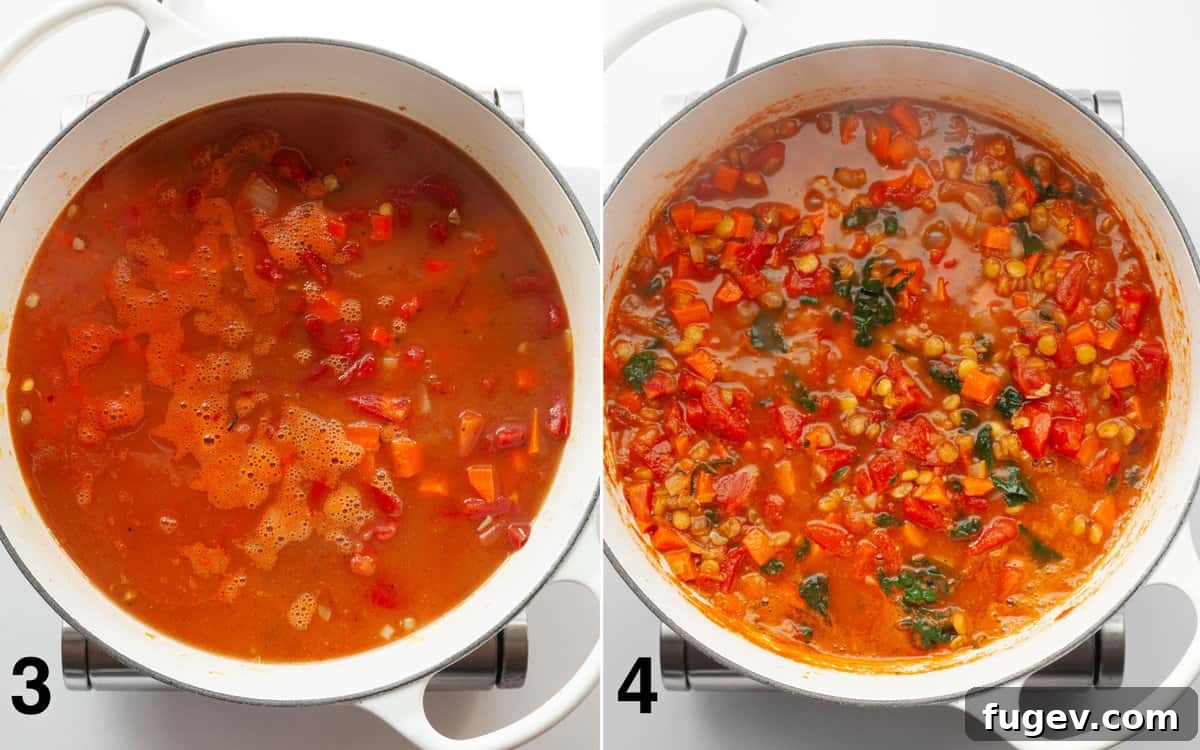 A large pot of green lentil soup simmering, with fresh kale leaves just stirred in, wilting into the broth.