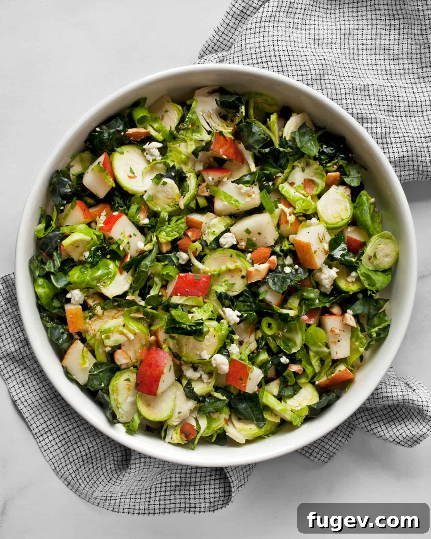 Sweet Pear and Shaved Brussels Kale Salad 2 A vibrant kale and brussels sprout salad with fresh pears, nuts, and crumbled blue cheese, drizzled with sherry vinaigrette, served in a rustic bowl, perfect for a healthy fall or winter meal.