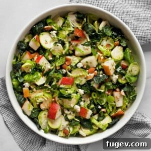 Kale brussels sprout pear salad in a bowl.