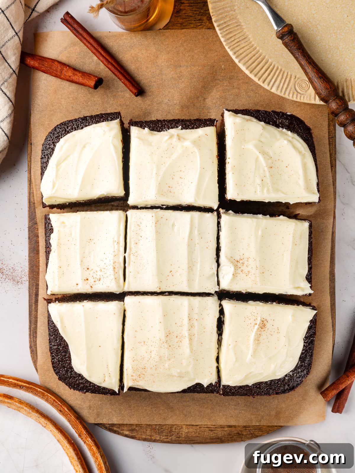Warm Spiced Gingerbread 13 Frosted gingerbread cake cut into squares with creamy topping spread evenly across the surface.