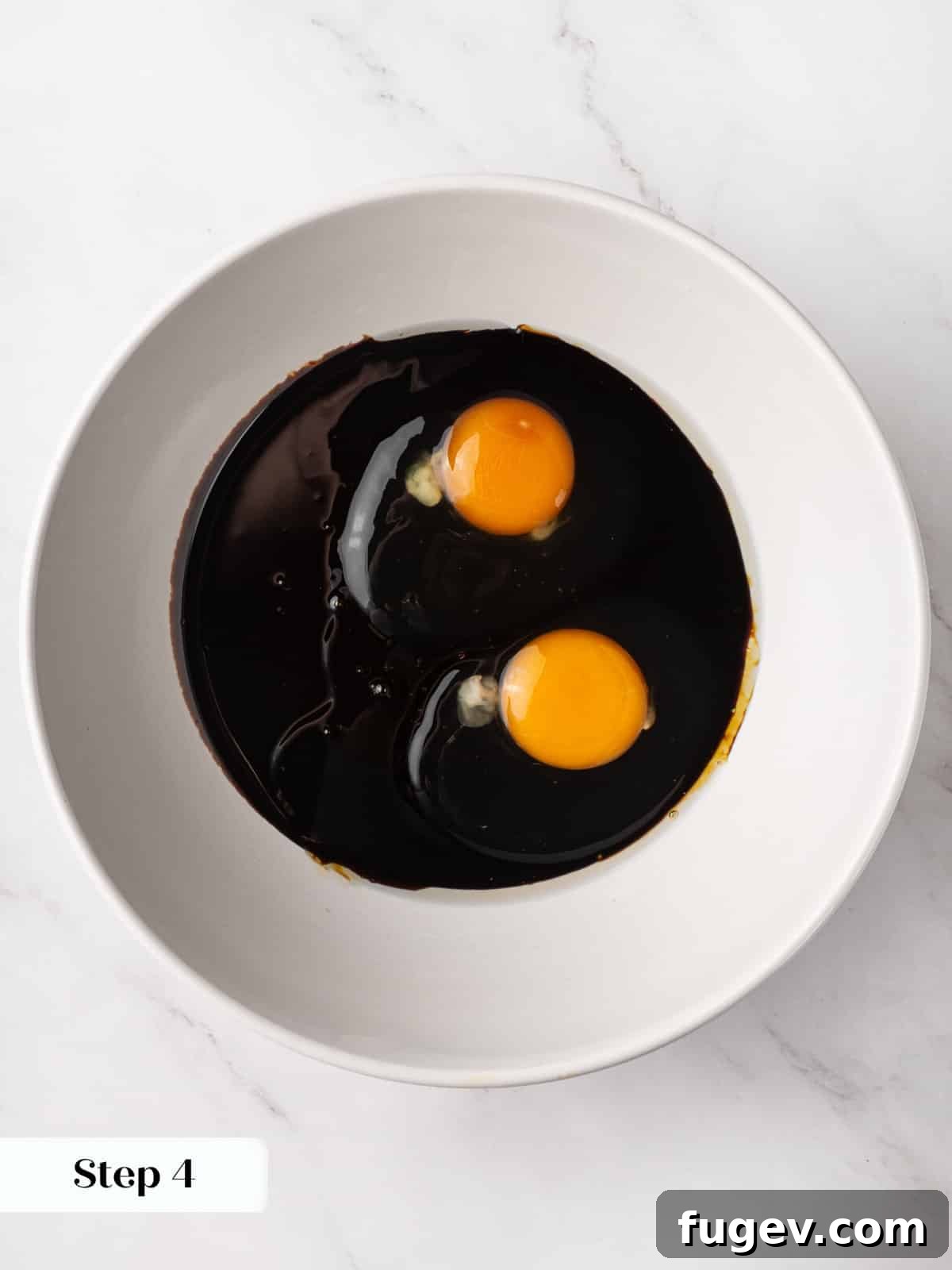 Warm Spiced Gingerbread 7 Dark molasses sitting with cracked eggs in a bowl before whisking together.