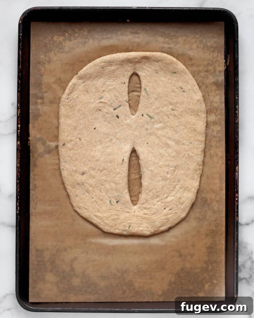 Fragrant Rosemary Fougasse 4 Step-by-step image demonstrating shaping the fougasse dough with a pizza cutter.
