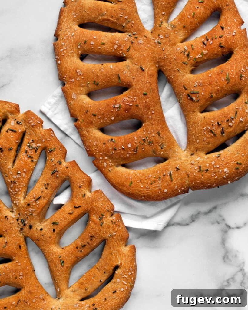 Fragrant Rosemary Fougasse 8 A golden brown Rosemary Fougasse loaf presented on a wooden board, ready to be enjoyed.