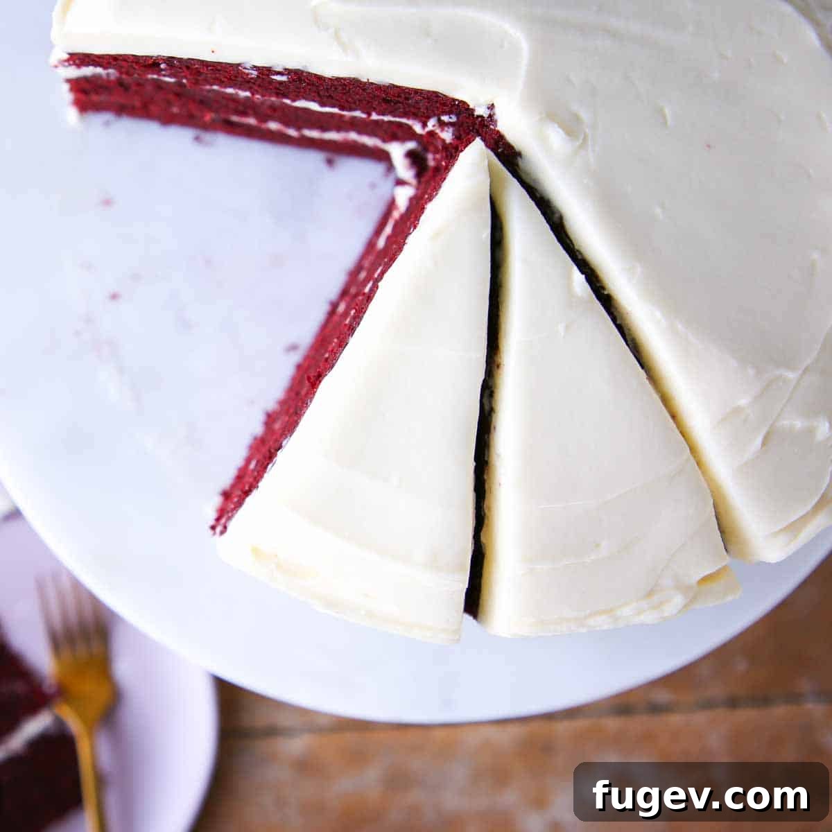 Lush Cream Cheese Buttercream 10 A slice of red velvet cake with bourbon cream cheese buttercream on a elegant marble cake stand.