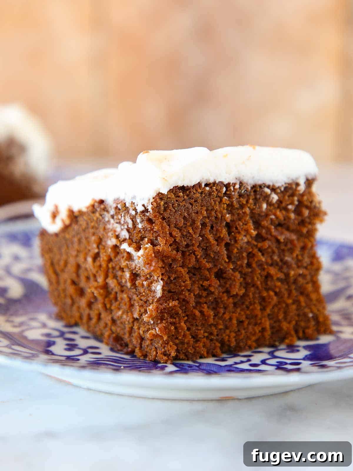 Lush Cream Cheese Buttercream 13 A slice of gingerbread cake with cream cheese frosting on a blue plate.