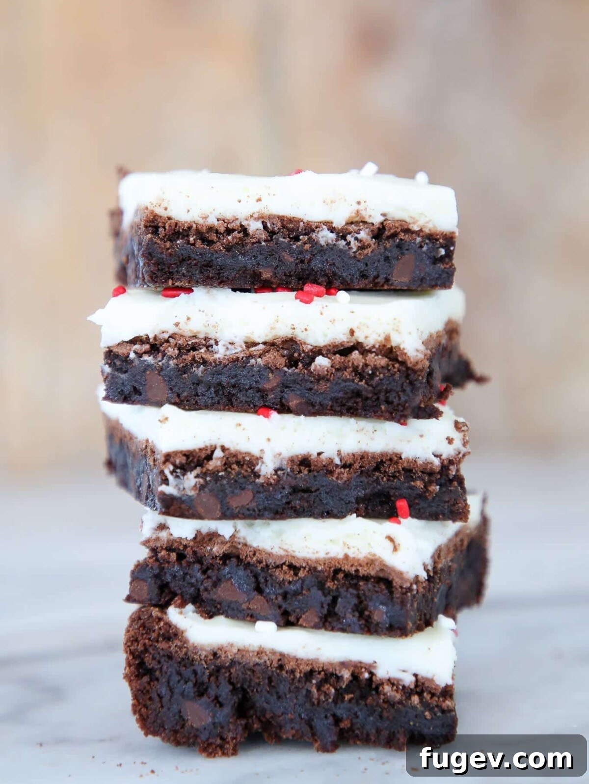 Peppermint Fudge Brownies 2 Stack of five fudgy peppermint brownies, showcasing their rich chocolate base and creamy white peppermint frosting, ready for holiday festivities.