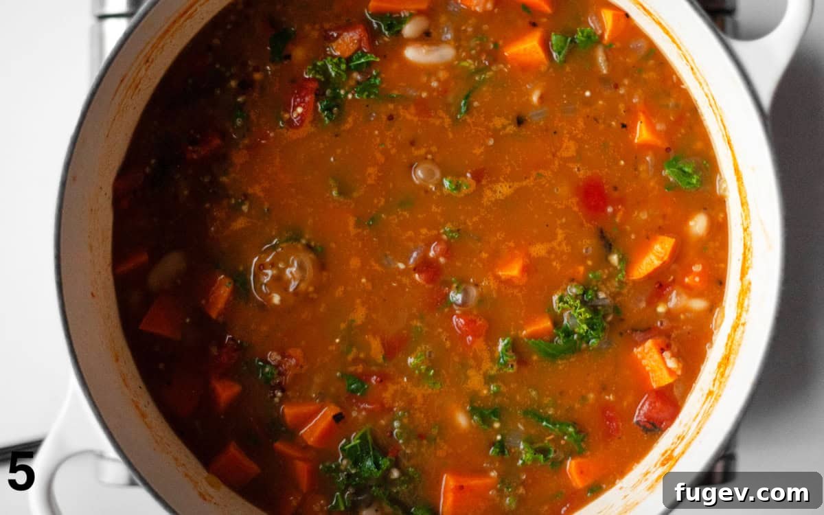 Sweet Potato White Bean Quinoa Bowl 6 Soup with kale simmered in a large pot, ready to be served.