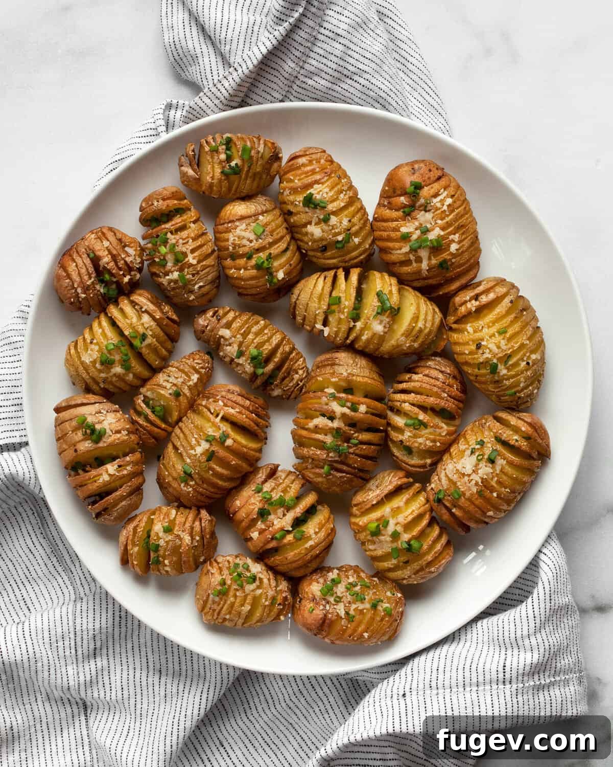 Crispy Accordion Bites 2 Beautifully arranged mini hasselback potato bites on a white plate, showcasing their crisp edges and golden-brown perfection, ready to be served.