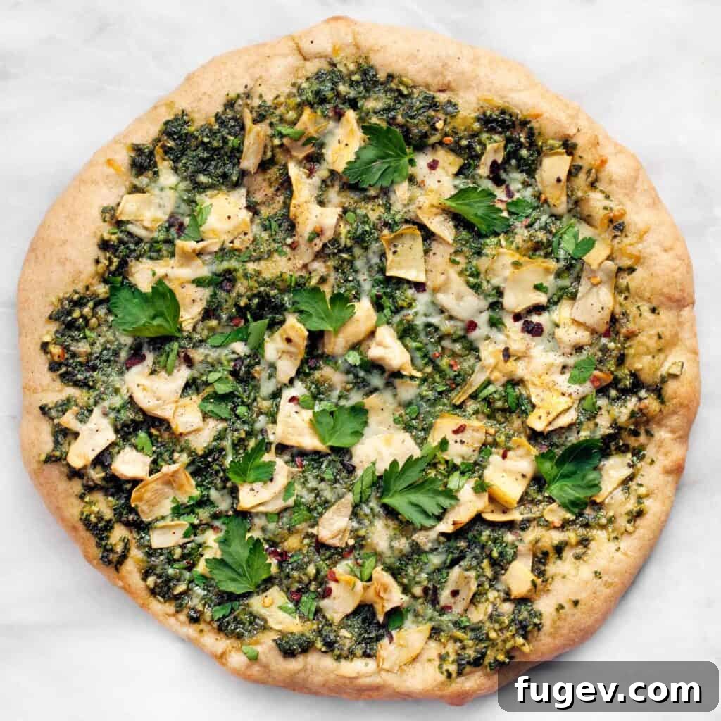 Creamy Spinach Artichoke Pizza 3 Close-up of baked Spinach Artichoke Pizza showing the textured pesto and melted cheese