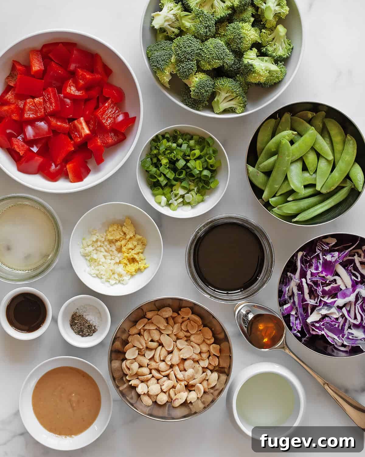 Nutty Vegetable Stir-Fry 3 A selection of fresh stir-fry ingredients including colorful bell peppers, broccoli florets, red cabbage, snap peas, peanuts, and sauce components.