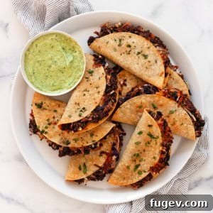 Crispy black beans tacos on a serving plate with avocado sauce in a small bowl.