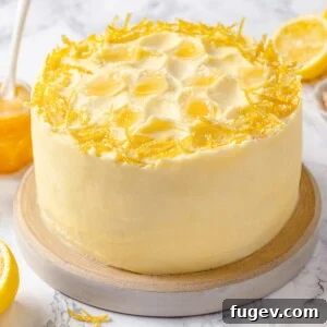 Cake topped with lemon Swiss meringue buttercream and fresh lemon peel garnish.