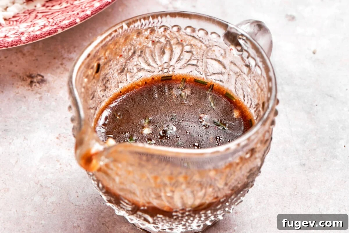 A small glass gravy dish filled with golden lemon balsamic dressing, ready to be poured and enjoyed.