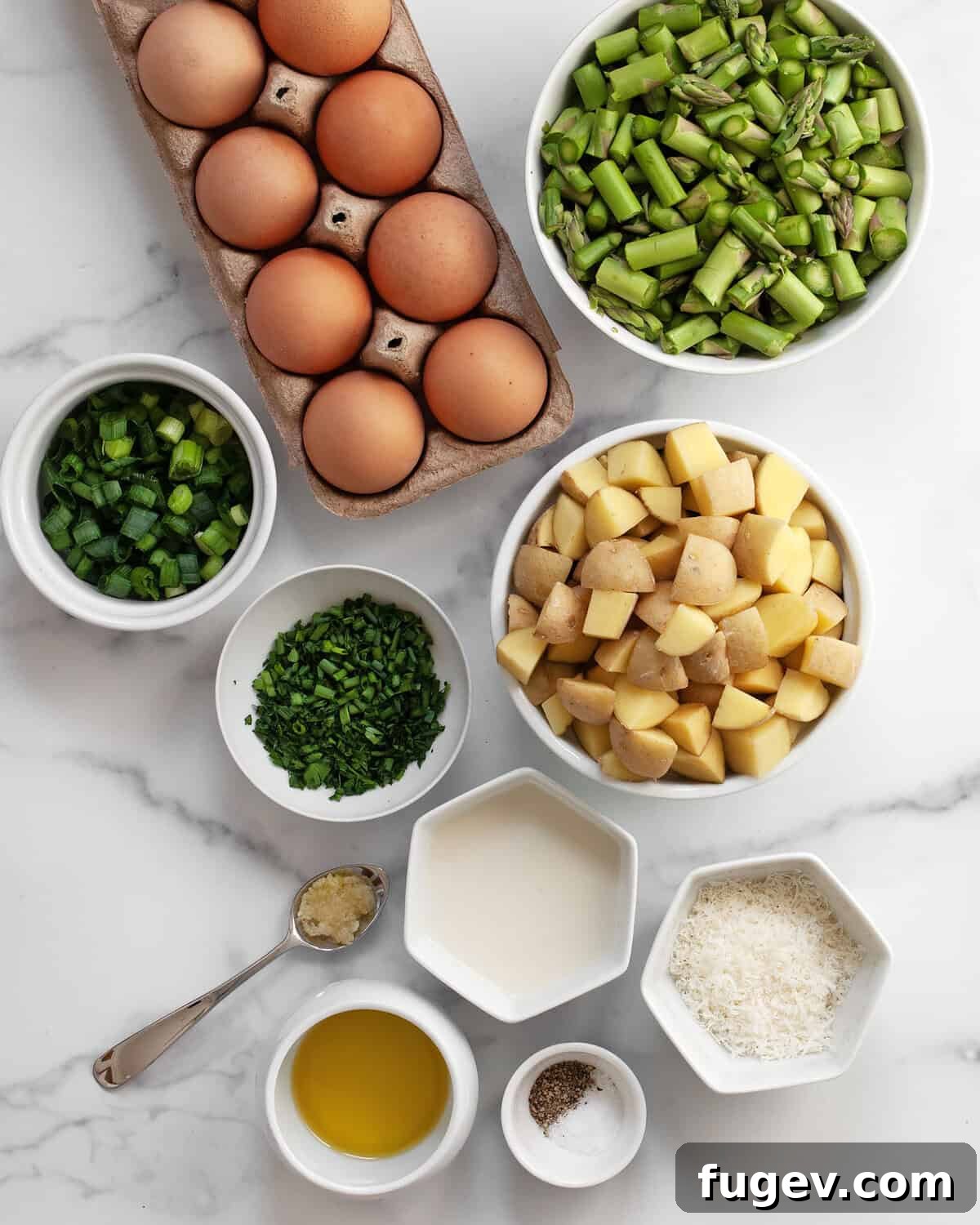 Fresh ingredients laid out: 8 large eggs, vibrant green asparagus, small baby potatoes, fresh chives and parsley, milk, grated parmesan cheese, minced garlic cloves, sliced scallions, olive oil, kosher salt, and black pepper.