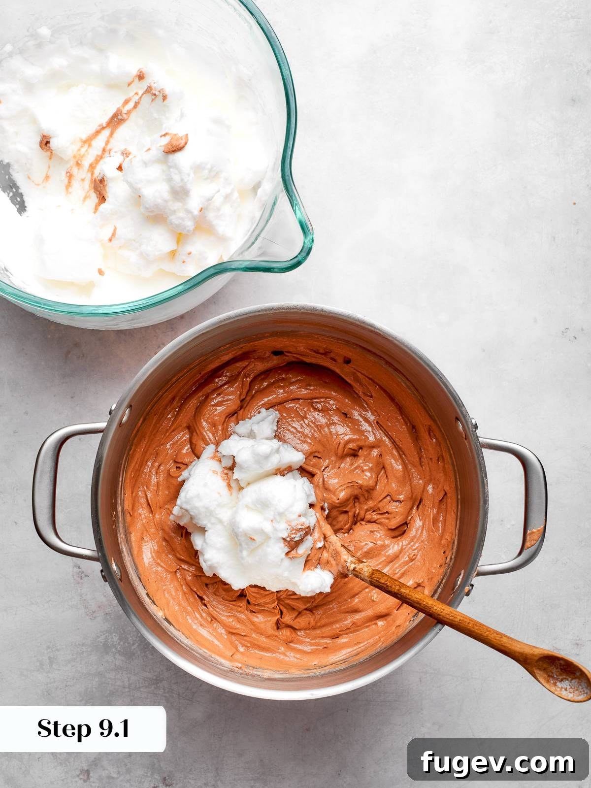Decadent German Chocolate Cake 14 A spoon gently folding stiff egg whites into the chocolate cake batter to maintain its airy structure and lightness.