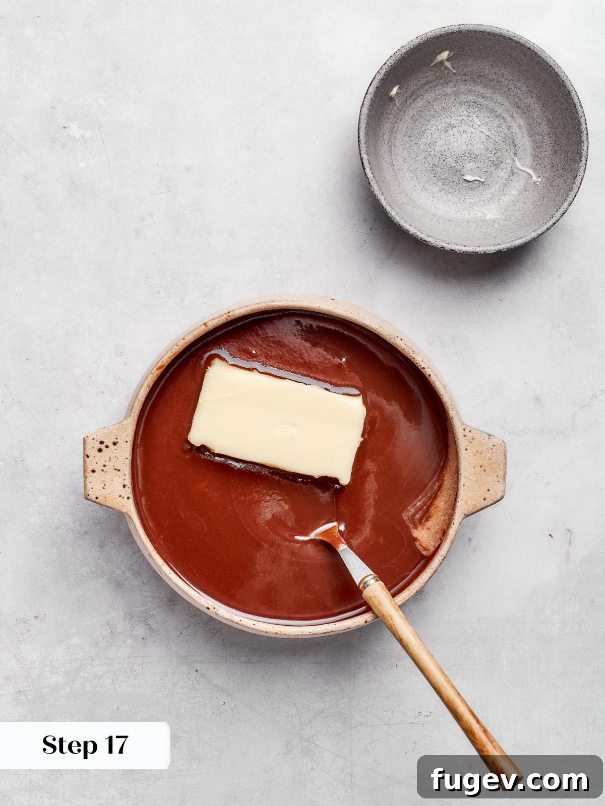 Decadent German Chocolate Cake 22 Softened butter ready to be whisked into warm chocolate ganache until it becomes glossy and smooth, enhancing its richness and texture.