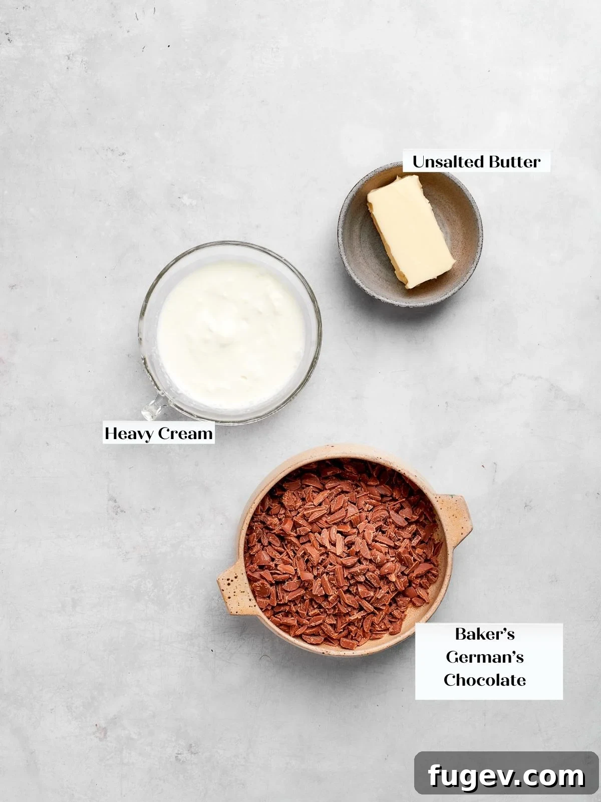 Decadent German Chocolate Cake 6 Ingredients for German chocolate cake ganache, such as chocolate and heavy cream, displayed on a white countertop.