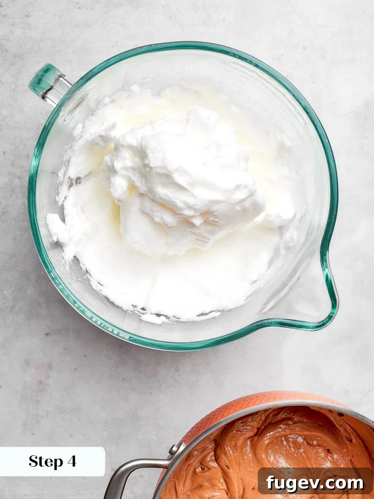 Decadent German Chocolate Cake 9 Egg whites beautifully whipped to stiff peaks in a mixer bowl, ready to be gently folded into the cake batter for an airy texture.
