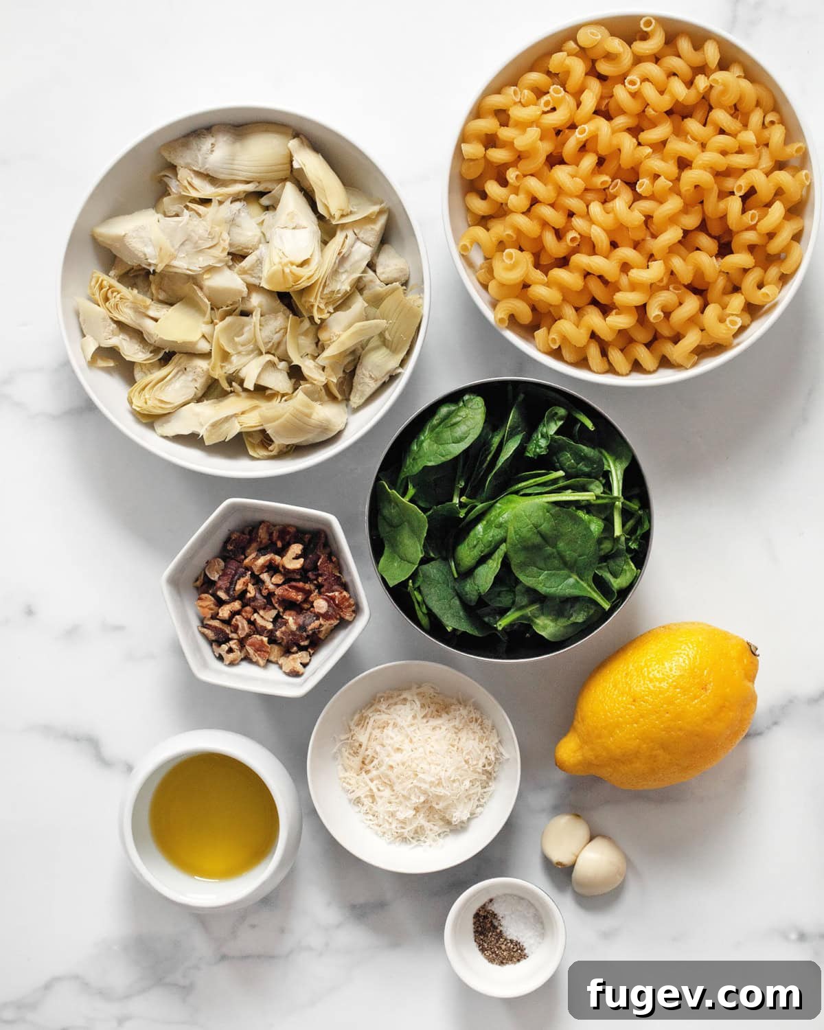 Spinach Artichoke Pasta Bake 3 All the key ingredients for spinach artichoke pasta laid out: spinach, artichokes, pasta, walnuts, parmesan, lemon, garlic, olive oil, salt, and pepper.