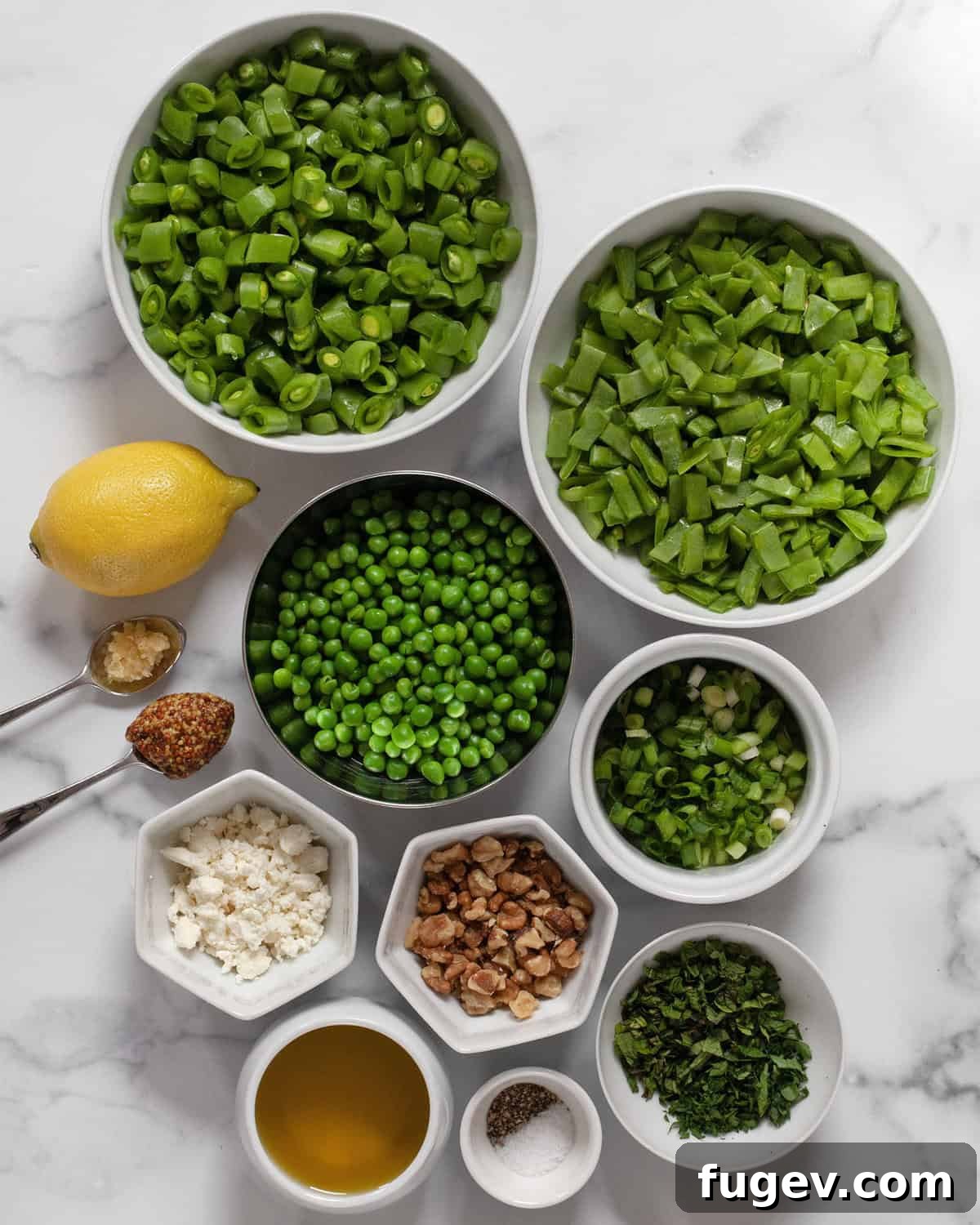 Triple Pea Delight 3 Ingredients for three pea salad including chopped snap peas and snow peas, shelled green peas, walnuts, scallions, feta, lemon, garlic, mustard, olive oil, salt, pepper, parsley and mint arranged beautifully.