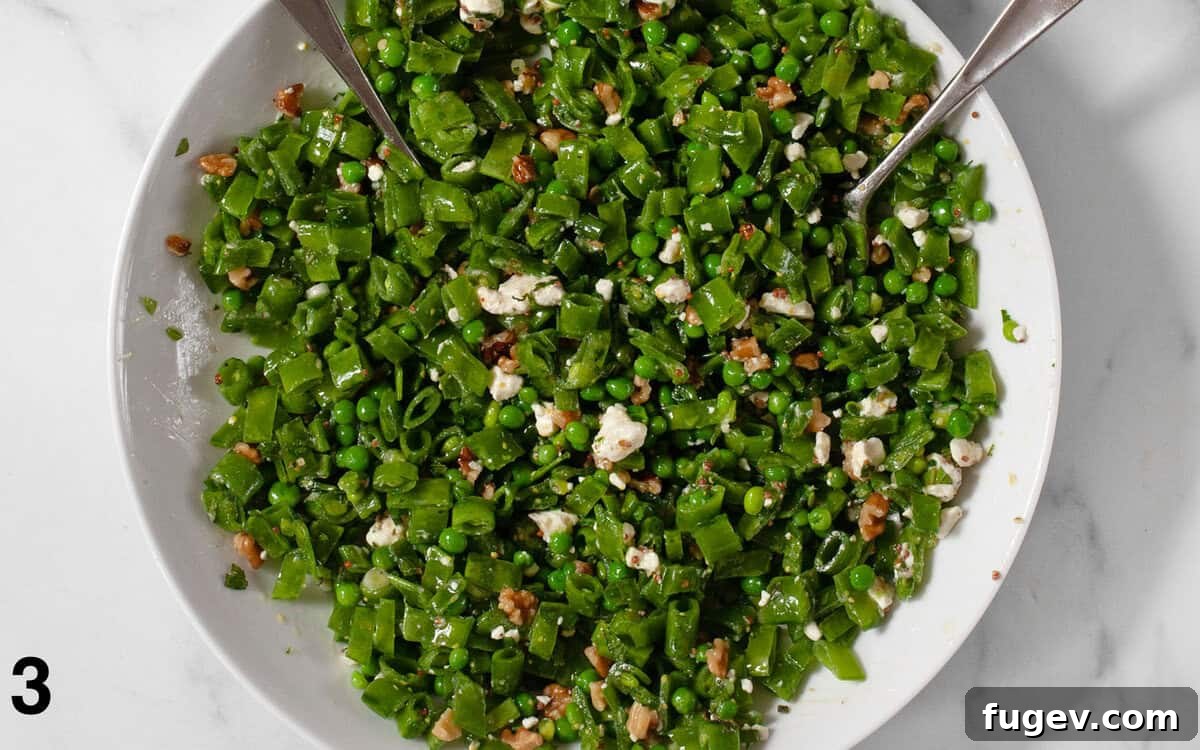 Triple Pea Delight 5 Three pea salad tossed with lemon vinaigrette in a large serving bowl, showcasing its vibrant color and textures.