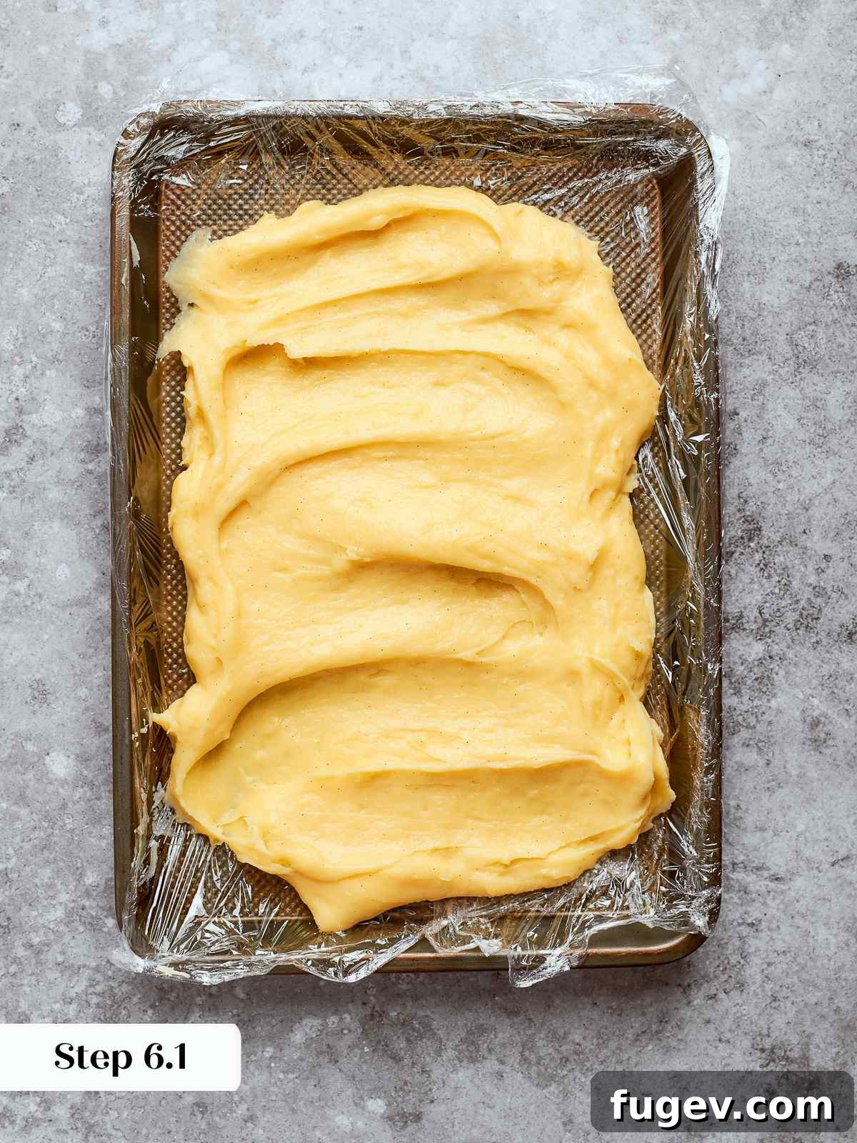 Sweet Cream Clouds 13 Hot pastry cream spread on a lined sheet pan to cool quickly and evenly, ensuring rapid chilling.