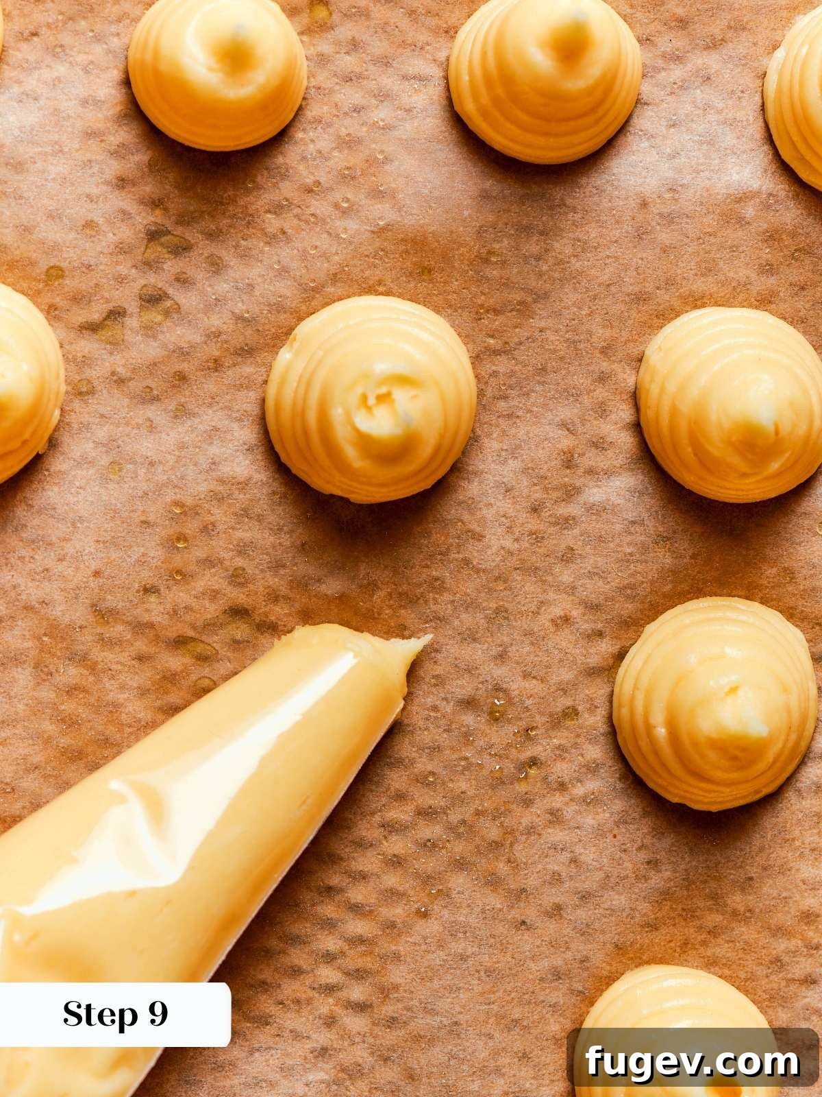 Sweet Cream Clouds 23 Piped choux pastry rounds on parchment paper, evenly spaced and ready for egg wash.