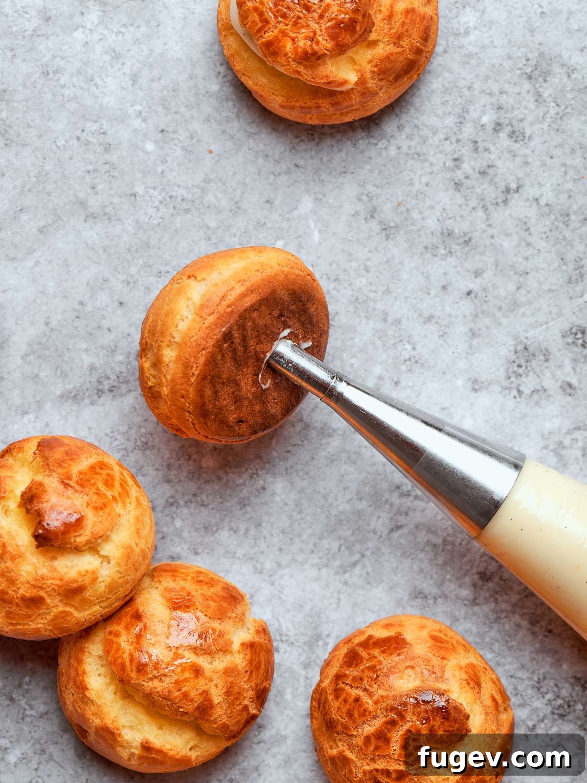 Sweet Cream Clouds 33 Piping bag filling cream puff shells with silky crème légère through small openings, a precise technique.