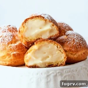 Golden cream puffs filled with light crème légère arranged on a serving plate.