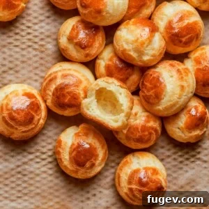 A single baked choux pastry with a rich golden color, indicating a perfectly crisp exterior and hollow interior from proper oven drying.