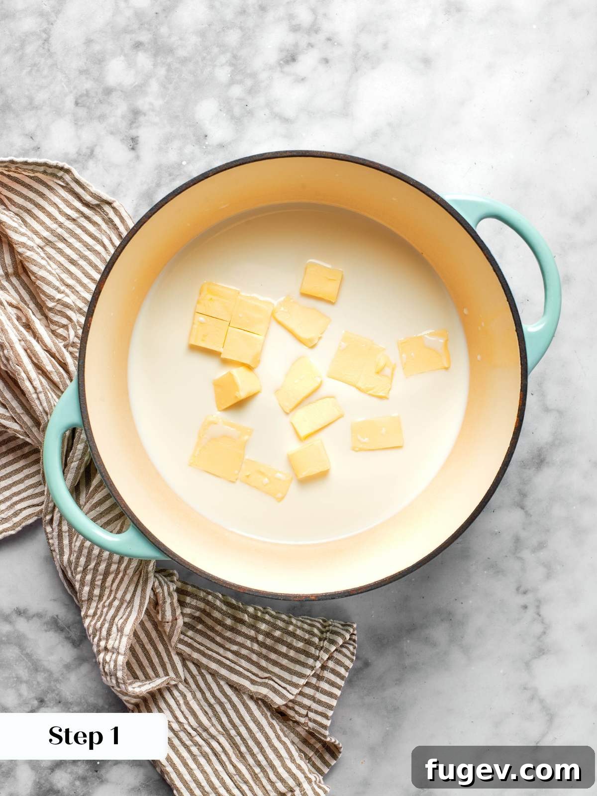 Cubed unsalted butter and whole milk starting to heat in a heavy-bottomed saucepot, ready for the panade stage of choux pastry.