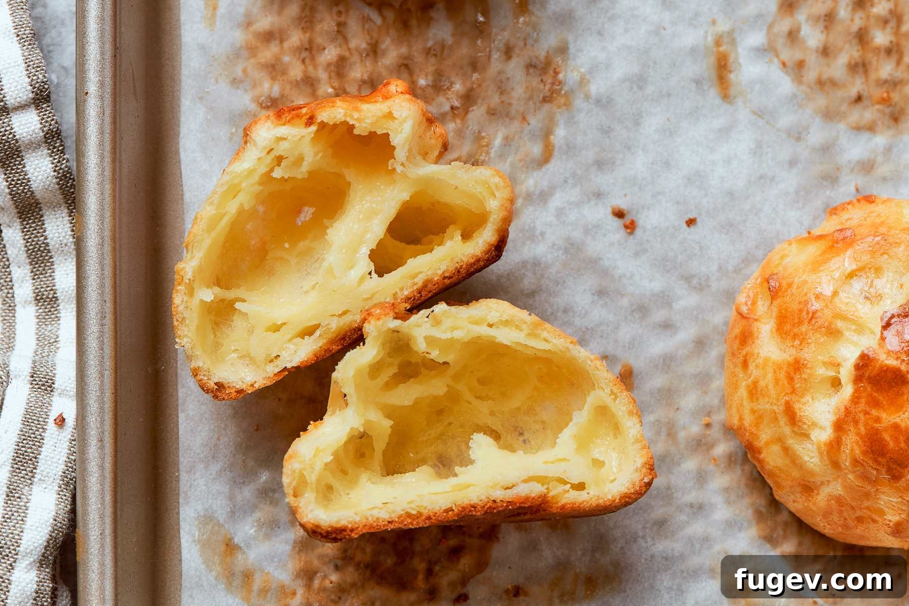 Golden Savory Puffs 6 Gougère sliced cleanly in half showing hollow center and tender interior crumb. A perfect cross-section revealing the airy structure.