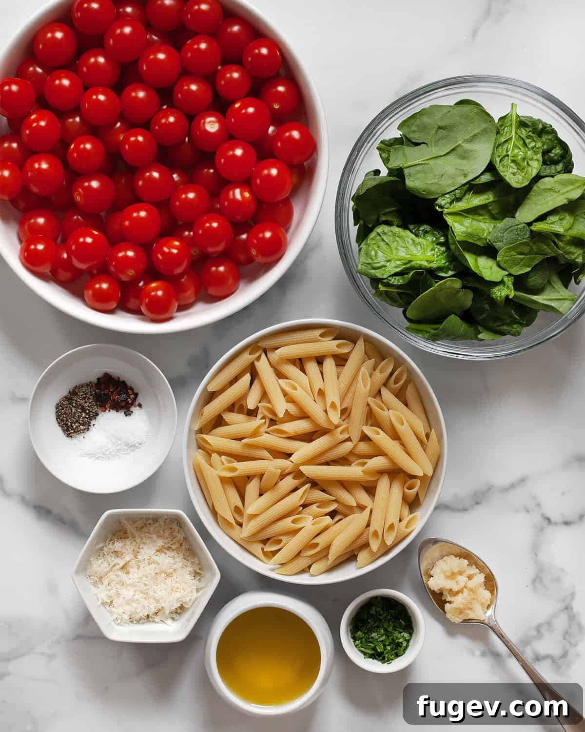 Ingredients including cherry tomatoes, penne, baby spinach, dried seasonings, garlic, olive oil, parmesan, garlic and fresh herbs