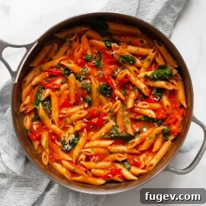 Spinach tomato pasta in a skillet.