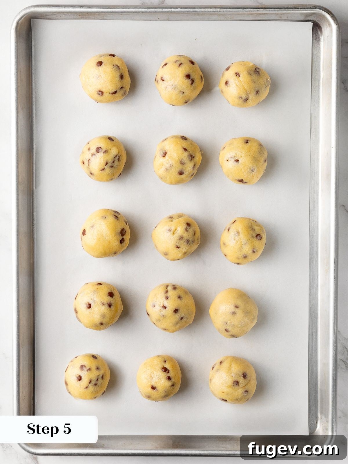 Perfectly portioned cookie dough balls on a parchment-lined baking sheet before chilling.