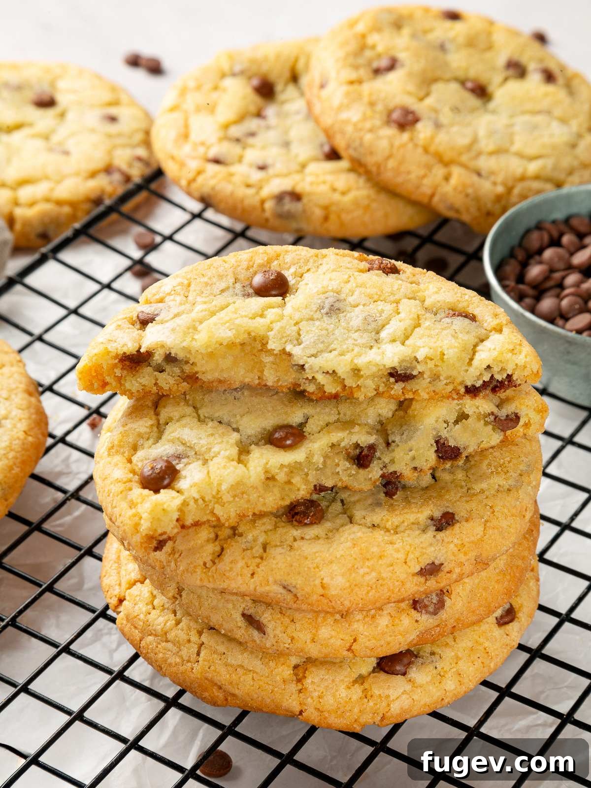 A close-up shot of a cookie broken in half, revealing a soft, chewy interior filled with melted chocolate chips.