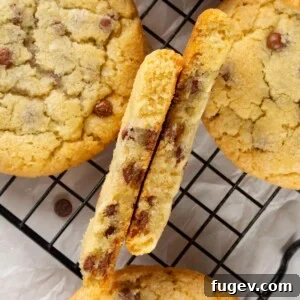 A chocolate chip cookie made without brown sugar, broken in half to show the thick, soft, and slightly gooey interior.