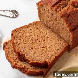 Tight square framing of the cut loaf and two slices showing tender cinnamon-flecked crumb in detail.