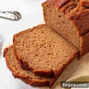 Tight square framing of the cut loaf and two slices showing tender cinnamon-flecked crumb in detail.