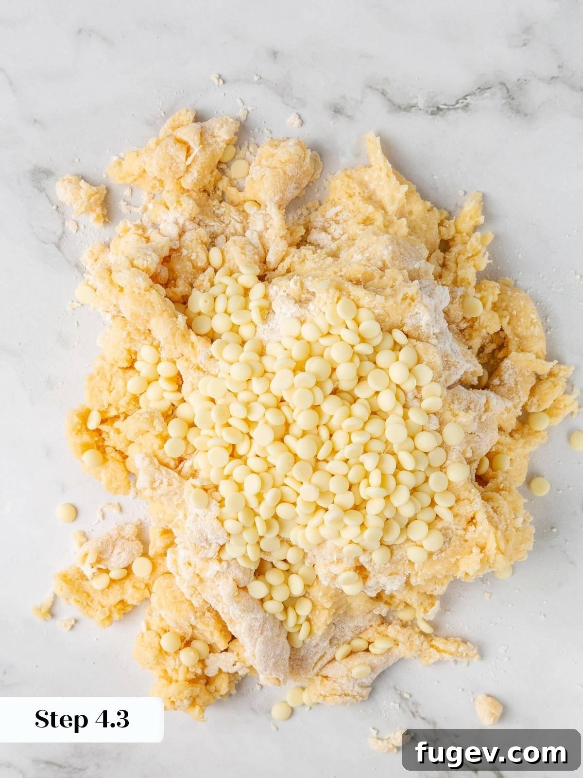 White Chocolate Raspberry Bliss Scones 12 White chocolate chips being added to the shaggy scone dough on the counter.