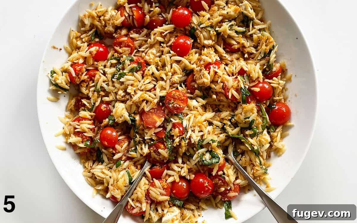 Breadcrumbs stirred into pasta salad in a large bowl.