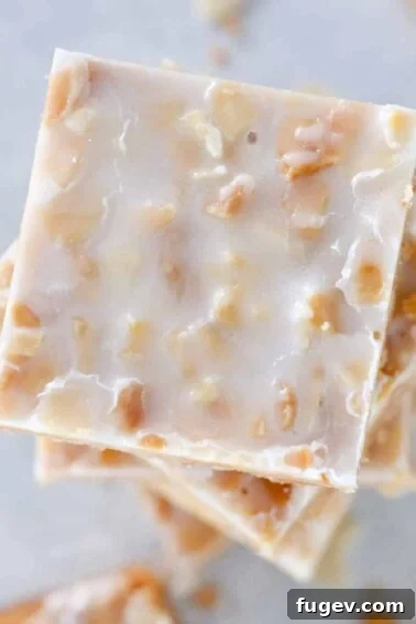 Square crispy almond cookies stacked on top of each other.